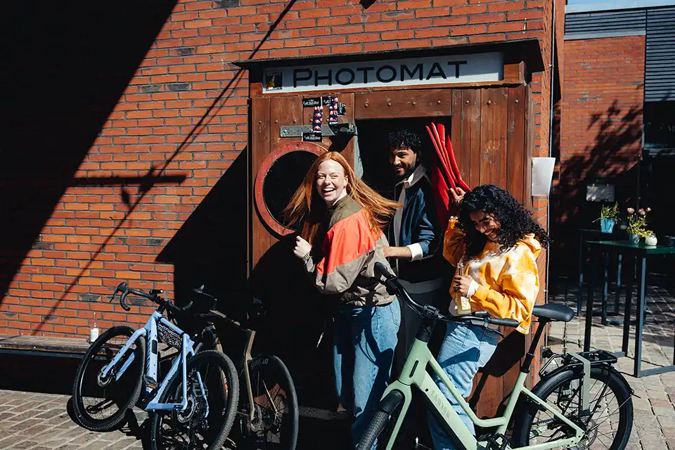 Junge Menschen vor einer Photobox mit Leasing Fahrädern
